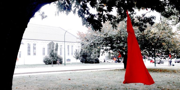 Art installation at Seaforth Peace Park in Vancouver, BC, inspired by Métis artist Jaime Black's REDress Project. The red dresses symbolize the missing and murdered Indigenous women and girls in Canada. (courtesy Edna Winti/Flickr CC)